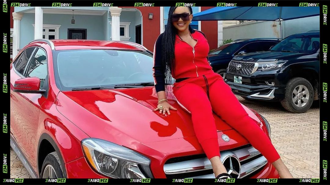 mercy aigbe sitting on her car
