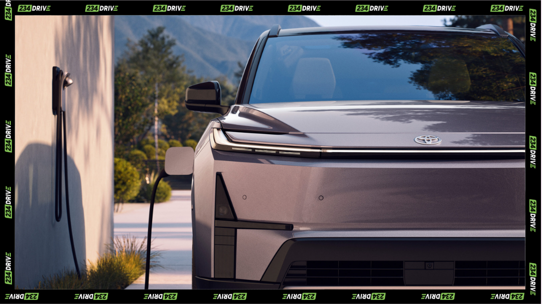 The Toyota 2027 Highlander EV charges at home, highlighting its sleek front end and smooth, sealed grille
