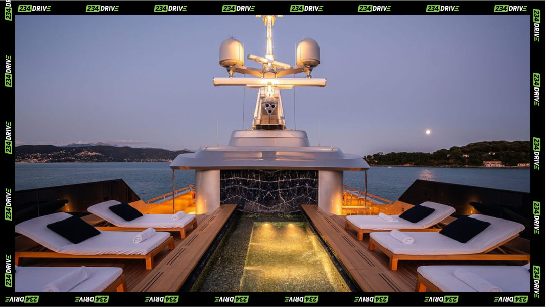 The marble-lined upper deck pool glows at dusk, framed by teak loungers and open sea. Superyacht Regina D’Italia
