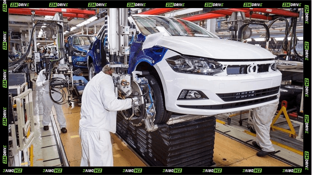 Workers assemble vehicles inside a South Africa factory, highlighting active car production and modern manufacturing.