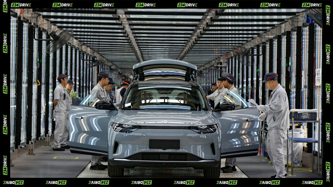 China's EV factory, factory workers assembling a passenger EV