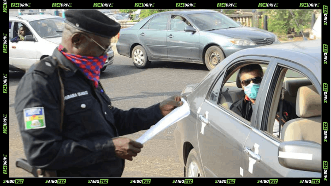 Nigerian police officer checks motorist documents during roadside enforcement on vehicle registration and number plate compliance.