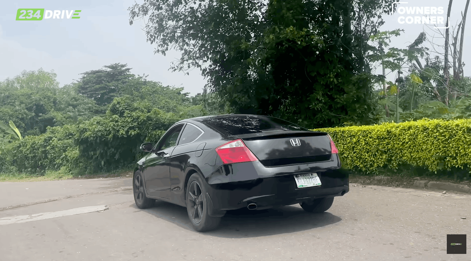The rear view highlights Bugsy’s black Honda Accord Coupe, twin exhaust outlets, dark wheels and two-door body on a Lagos road.