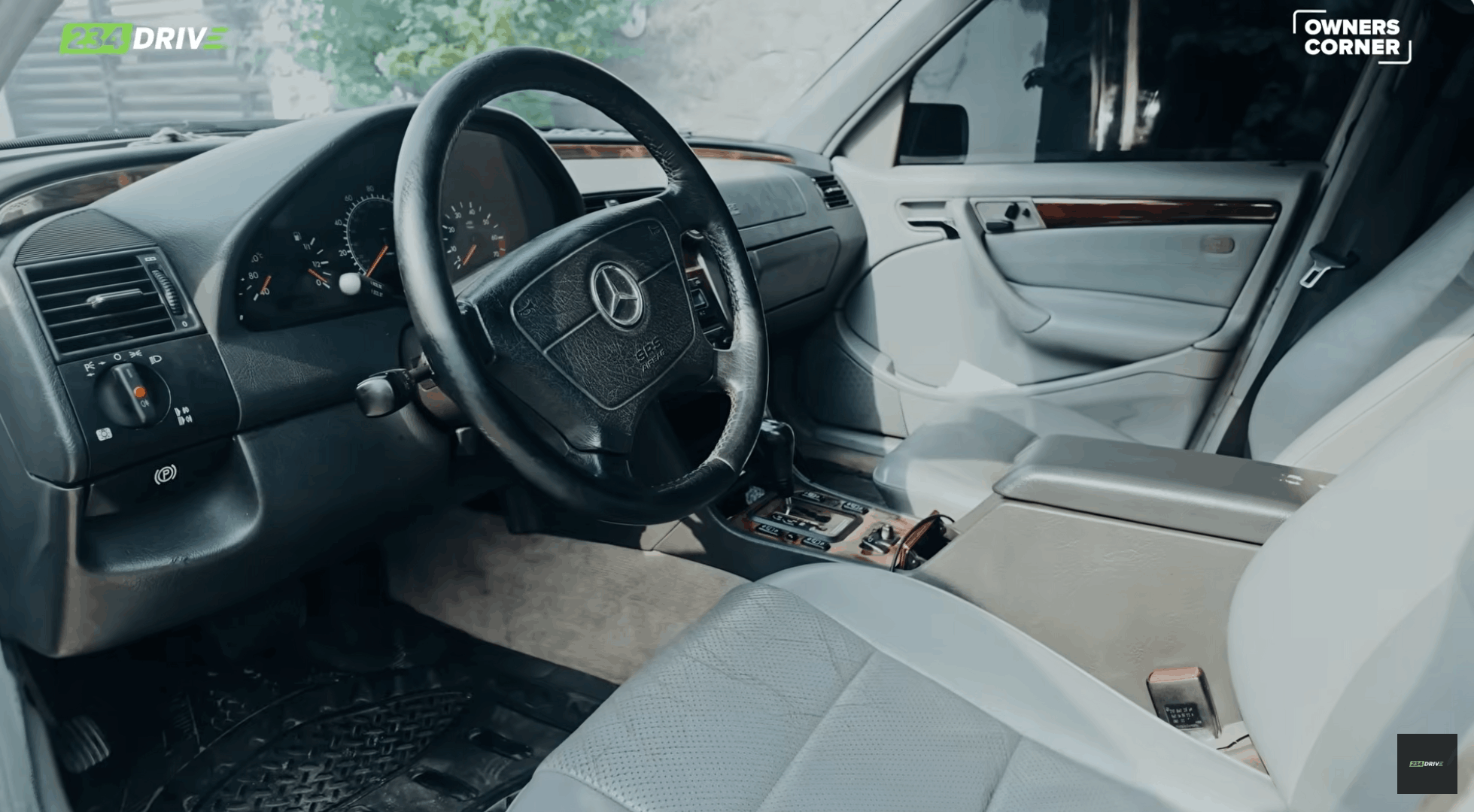 The 234Drive Owner’s Corner camera reveals the Mercedes-Benz C280 W202 cabin with grey leather seats, wood trim and analogue controls.