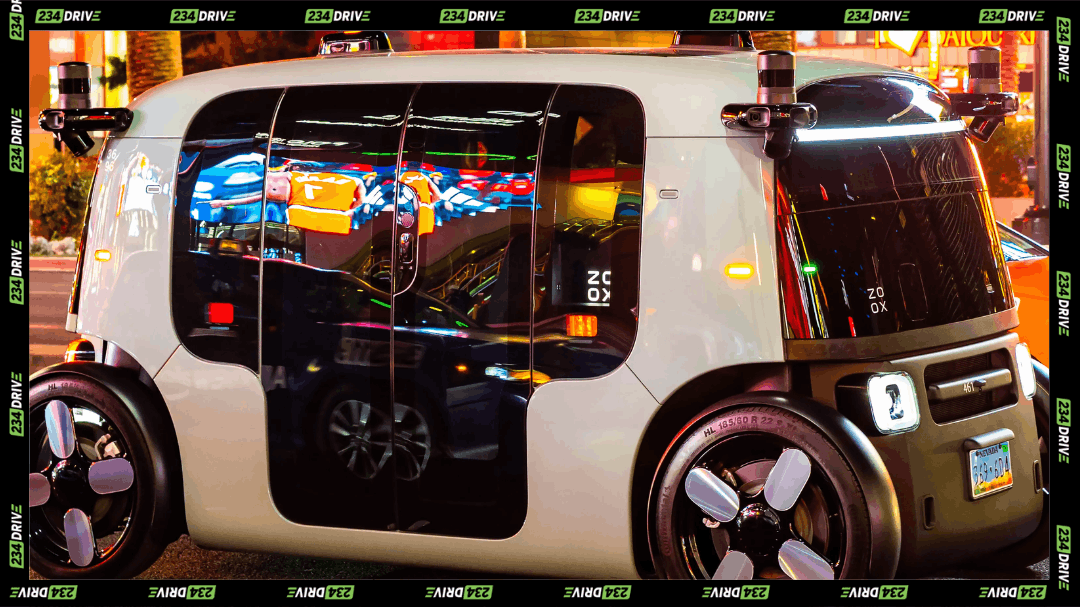 A Zoox robotaxi travels through a brightly lit city street as Amazon’s autonomous vehicle unit prepares to charge passengers under new US approval.
