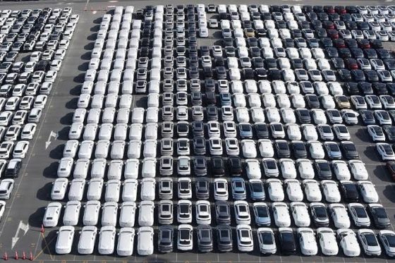 Rows of newly built Chinese electric vehicles parked at a port lot awaiting export