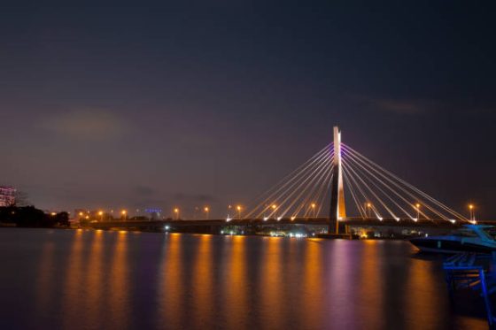 The illuminated Lekki-Ikoyi Link Bridge stretching across calm dark waters at night in Lagos Nigeria