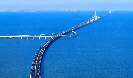 Aerial view of a long coastal bridge stretching across the blue sea.