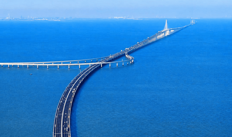 Aerial view of a long coastal bridge stretching across the blue sea.