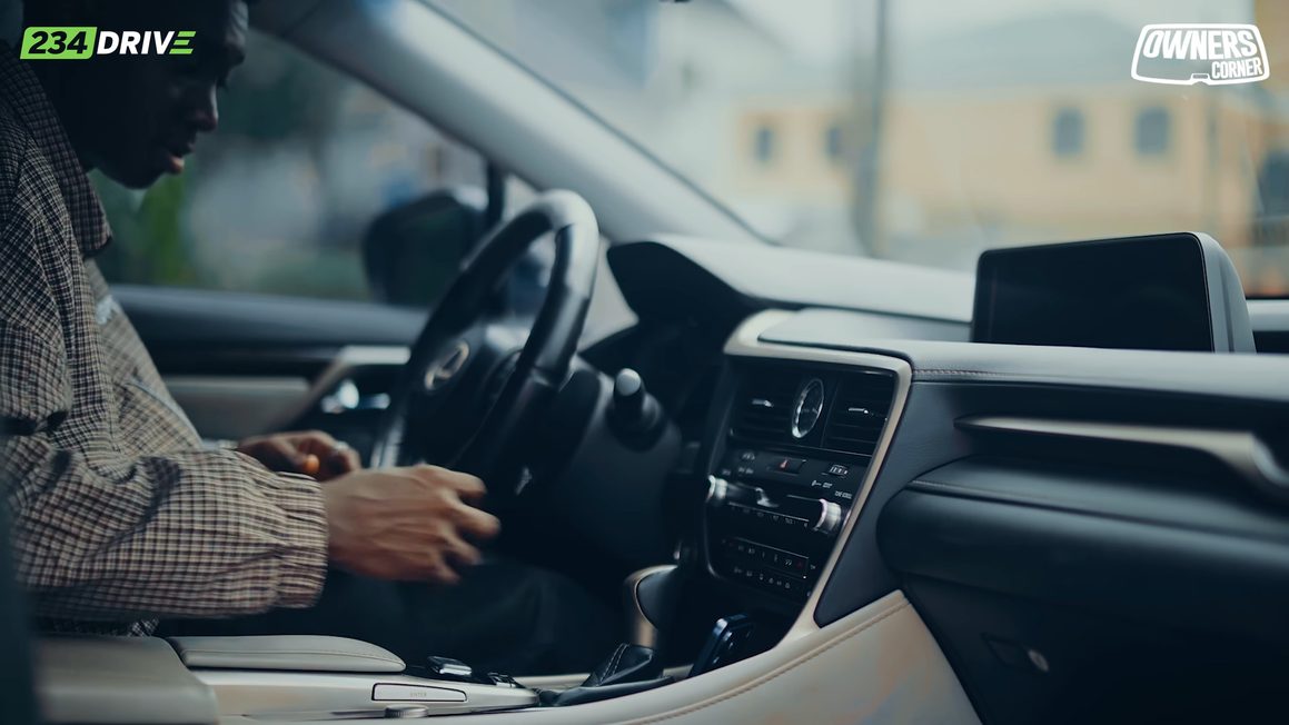 Timilehin in the driver’s seat of his Lexus RX350 with the dashboard and infotainment screen beside him